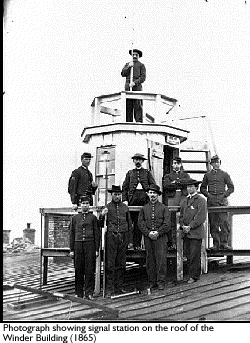 Photograph showing signal station on the roof of the Winder Building in 1865.